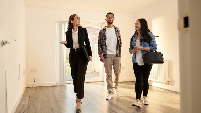 three people walking through a new home at The Acacia