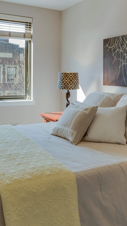 bed with comforter set beside table lamps on nightstands