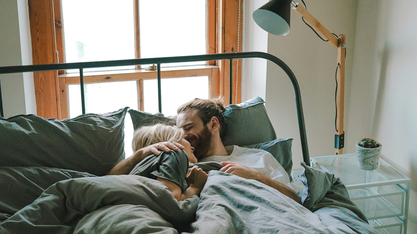 man kissing woman on her forehead